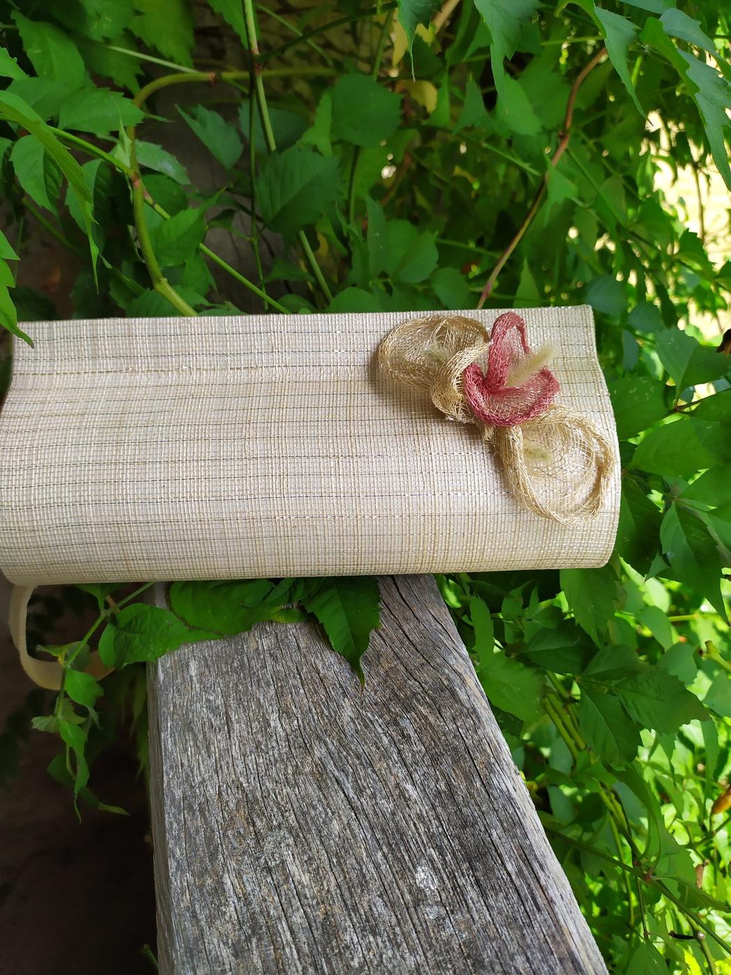 Pochette écrue ornée d'une fleur rose en extérieur